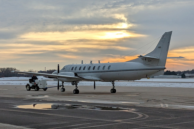 Maintenance specialists for the Wisconsin Air National Guard's RC-26B reconnasance aircraft tow it into an aircraft ramp at Dane County Regional Airport following it's final flight Dec. 28, 2022. The RC-26 has been stationed at Truax Field since January 1992, and was assigned to the ANG Counter Drug Program in 1996 supporting both state and federal counter narcotics, counter insurgency and homeland security missions. (U.S. Air National Guard photo by Senior Master Sgt. Paul Gorman)